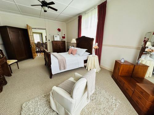 a bedroom with a bed and a chair and a couch at Casa del Cafe-Familiar in Heredia