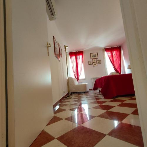 a bedroom with red curtains and a checkered floor at San Marco Suite Cosaro in Venice
