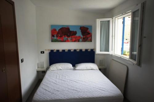 una camera da letto con letto con testiera blu e finestra di Casetta Azzurra a Pomonte