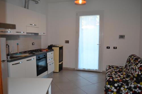 a kitchen with a stove and a couch in a room at Casetta Azzurra in Pomonte