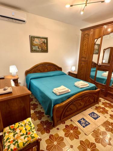 a bedroom with a bed with blue sheets and a mirror at Casa limone Anna e Clemente Cilento in Sapri