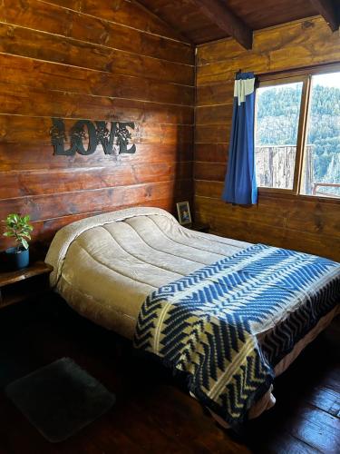 a bedroom with a bed in a wooden cabin at Cabaña de montaña Amber in San Carlos de Bariloche