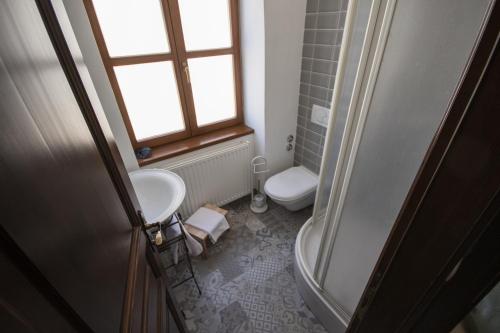 a bathroom with a sink and a toilet and a window at Hotel Ovo malo duše in Sarajevo