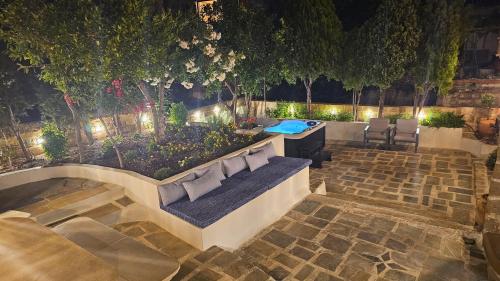 a bench with pillows on it in a garden at night at Old Town Pearl in Rhodes Town