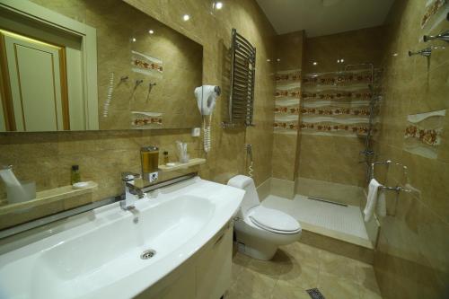 a bathroom with a sink and a toilet and a shower at Agava Tbilisi in Tbilisi City