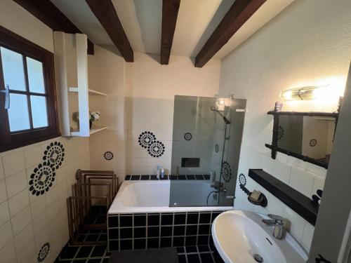 une salle de bain avec une baignoire et un lavabo dans l'établissement Maison Longarisse, à Lacanau