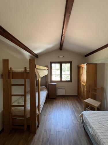 une chambre avec deux lits superposés et une fenêtre dans l'établissement Maison Longarisse, à Lacanau