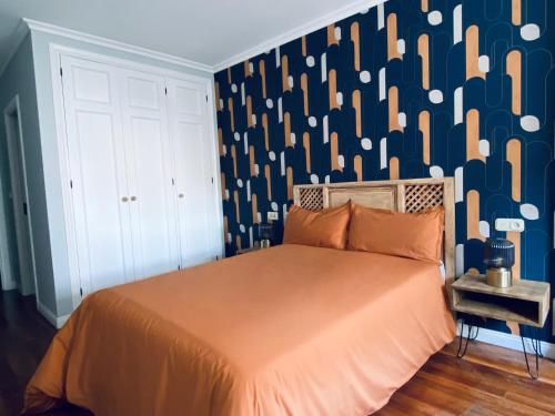 a bedroom with a large bed with a wall with aoc at Piso Céntrico 120m2 + parking propio (O Grove) in O Grove
