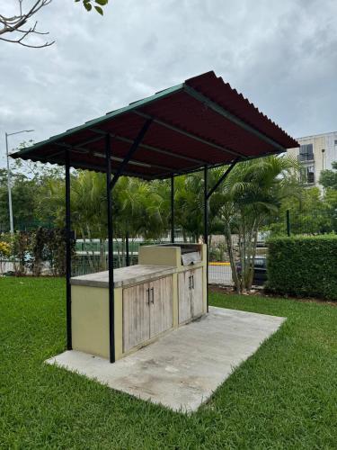 a picnic table with a canopy on a field of grass at House in front of the Maya Playa del Carmen train in Cedro