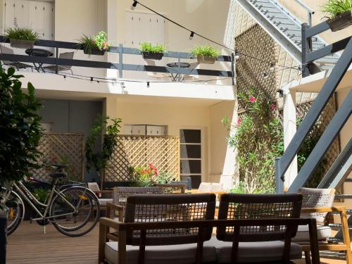 a patio with tables and chairs and bikes on a building at Hotel de Paris in La Rochelle