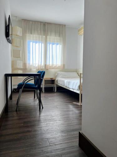 a room with a desk and a bed and a table and chairs at La Ermita in Brunete