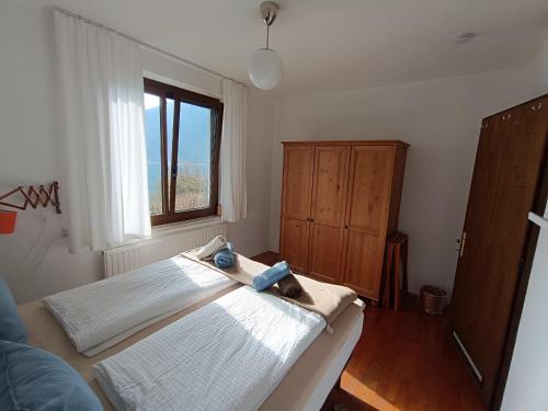 梅佐拉戈Ledro Casa Pino al Lago mit direktem Seezugang的一间卧室，里面有一张床和一扇窗户。