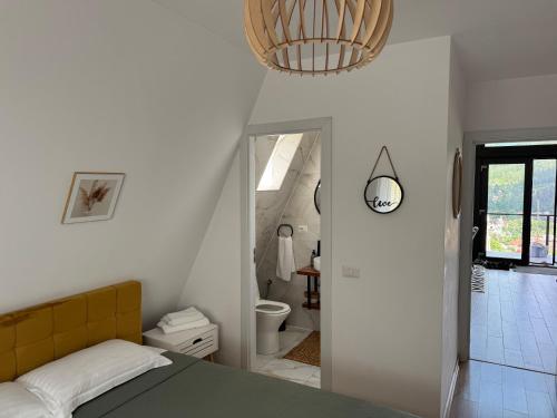 a bedroom with a bed and a bathroom at Ambiance Aframe in Câmpulung Moldovenesc
