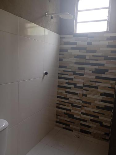 a bathroom with a shower with a glass door at Casa em mosqueiro in Belém
