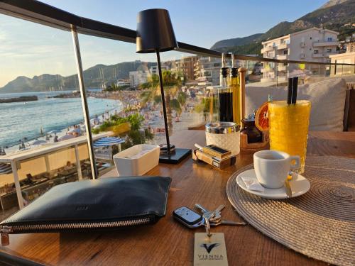 a table with a laptop and a cup of coffee on it at Vienna Luxury Apartments in Dobra Voda
