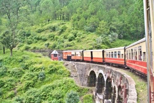 a train traveling over a bridge on a mountain at The Cloudberry Kasauli I Guaranteed Best Price I Serviced Villa I Open Air Rooftop I Couple Friendly I Pvt Balcony I Kasauli By ExoticStays in Kasauli