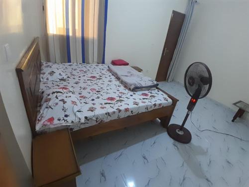 a small bed in a room with a fan at 2chambres salon villa Thierno sene in Niakoul Rap