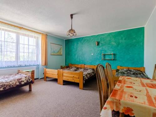 a room with two beds and a table with chairs at Róża Wiatrów in Rowy