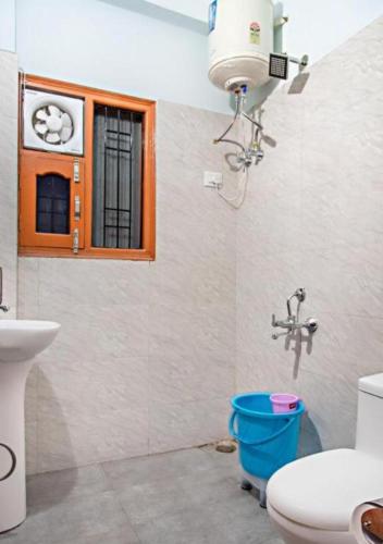 a bathroom with a toilet and a sink and a window at Exotic Stays I The Pine Trails I Serviced Apartments I Toy Train View I Best Seller I Guaranteed Best Price I Kasauli in Kasauli