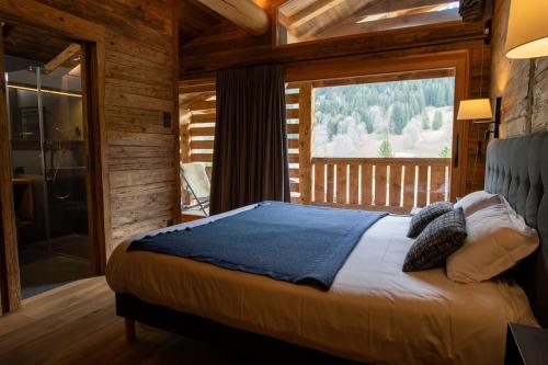 a bedroom with a bed and a large window at La Clusaz chalet Anthocyane 14 people, heated pool in La Clusaz