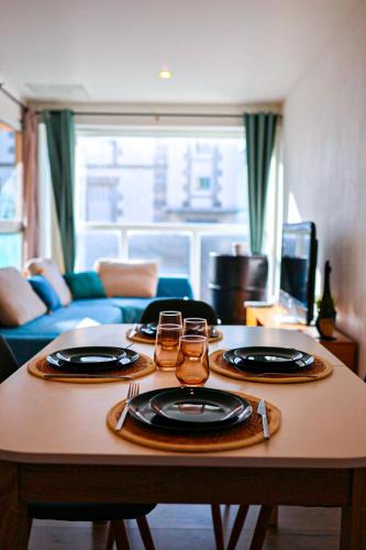 - une table avec deux assiettes et deux verres dans l'établissement Écrin cosy à deux pas du centre, à Lorient