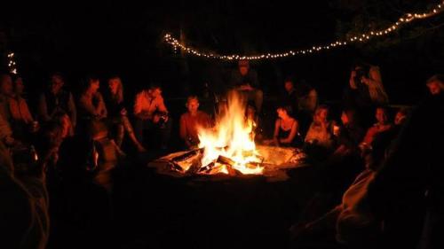 a group of people sitting around a large fire at Exotic Stays I The Kasauli Western Uphills I Vacations I Family Groups & Events I Forest Treks I Memories I Serviced Apartments I Kasauli in Kasauli