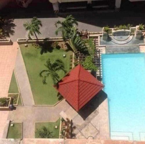 a red umbrella sitting next to a swimming pool at Condotel Cebu City in Cebu City