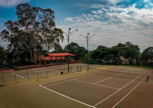 a tennis court with trees and a pavilion at Chalé Gratidão - Camping Carrion - ITU in Itu