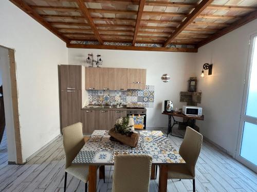 a dining room with a table and chairs and a kitchen at Sharon House 67 in Marsala