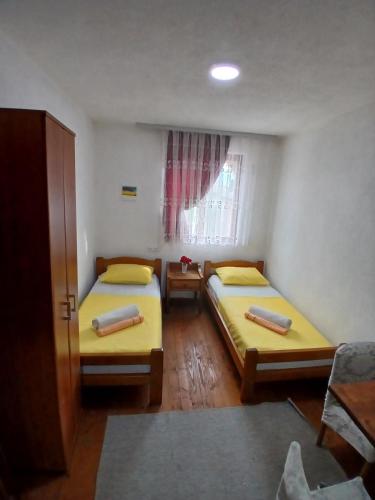 a bedroom with two beds and a window at Lago Apartment's in Kravlja