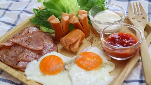 a plate of food with meat and vegetables on a table at Rawinnipha's Resort & Garden Khonkaen in Khon Kaen