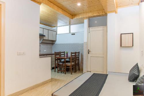 a kitchen and dining room with a door and a table at Exotic Stays I The Kasauli Western Uphills I Vacations I Family Groups & Events I Forest Treks I Memories I Serviced Apartments I Kasauli in Kasauli