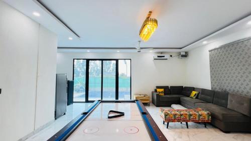 a living room with a glass table in the middle at The Dhaulidhar Farm in Greater Noida