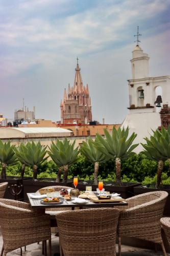 a table with food on a balcony with a view of a city at Hotel Casa Blanca 7 in San Miguel de Allende