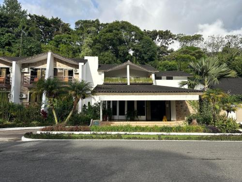 una casa blanca con palmeras y una calle en Hotel Ladera, en Boquete