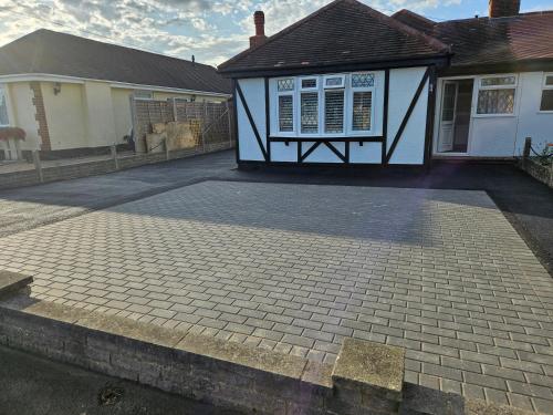 a house with a brick driveway in front of it at A Bright and Spacious Gem in Staines