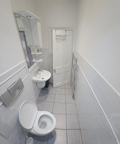 a white bathroom with a toilet and a sink at Bright & Modern Double Rooms in Central East London in London
