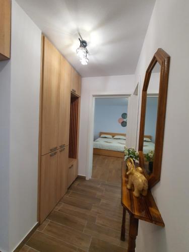 a hallway with a mirror and a dresser and a bedroom at BicazApart in Bicaz