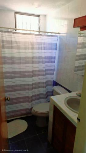 a bathroom with a toilet and a shower curtain at ideal para tus vacaciones in Pampatar