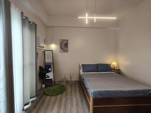 a small bedroom with a bed and a window at Cozy Staycation Near Cebu Airport with Pool & Gym , Free Wifi in Pusok