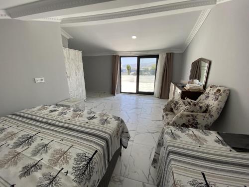 a bedroom with a bed and a couch and a chair at Ege Naz Villa in Avşa Adası