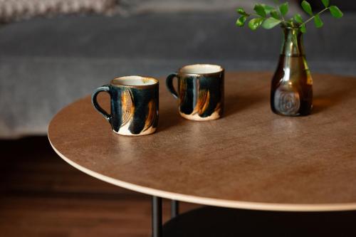 two coffee mugs sitting on a table with a vase at 陽月-Hizuki- in Nakijin