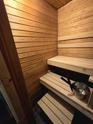 a wooden sauna with a pan and a bowl at Saunakaksio - cozy flat Pieksämäki in Pieksamaki