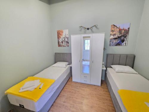 two beds in a small room with a door at Luka's Family Comfort Apartment in Prčanj