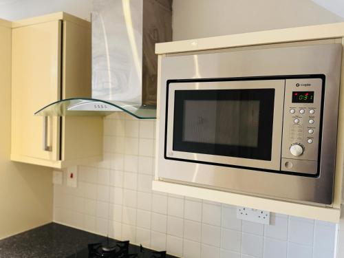 a microwave over a stove in a kitchen at Large Room Near City Centre in Belfast