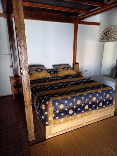 a bed with a wooden frame in a bedroom at Riad Marco Andaluz in Sale