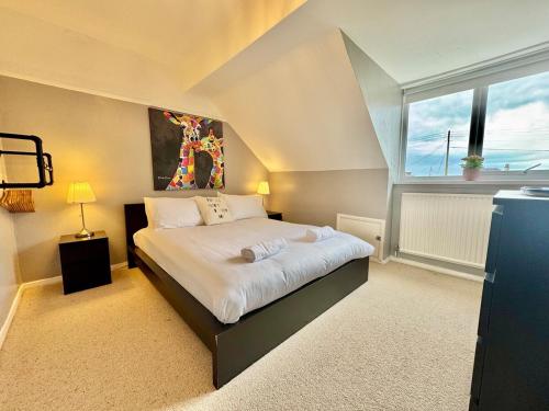 a bedroom with a bed and a large window at Penmorfa -4 Bed-3 Bath-Coastal Retreat Sleeps 9 in Trearddur
