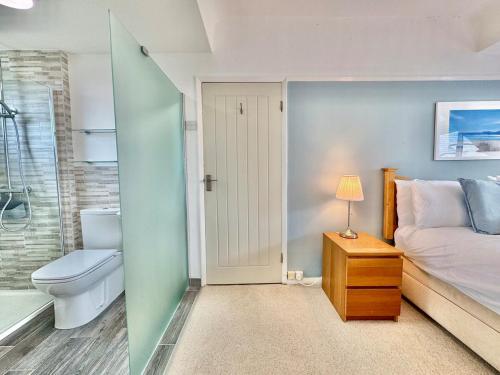 a bedroom with a bed and a bathroom with a toilet at Penmorfa -4 Bed-3 Bath-Coastal Retreat Sleeps 9 in Trearddur