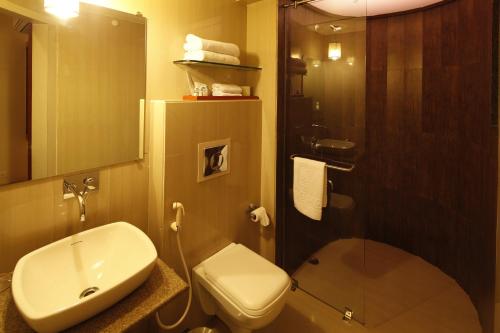 W łazience znajduje się umywalka, toaleta i prysznic. w obiekcie Sinclairs Siliguri w mieście Siliguri