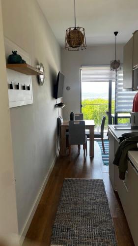 a kitchen with a table and a dining room with a window at Casa Montenegro 1 Plus 1 Suite View Sea and Pool in Kavač